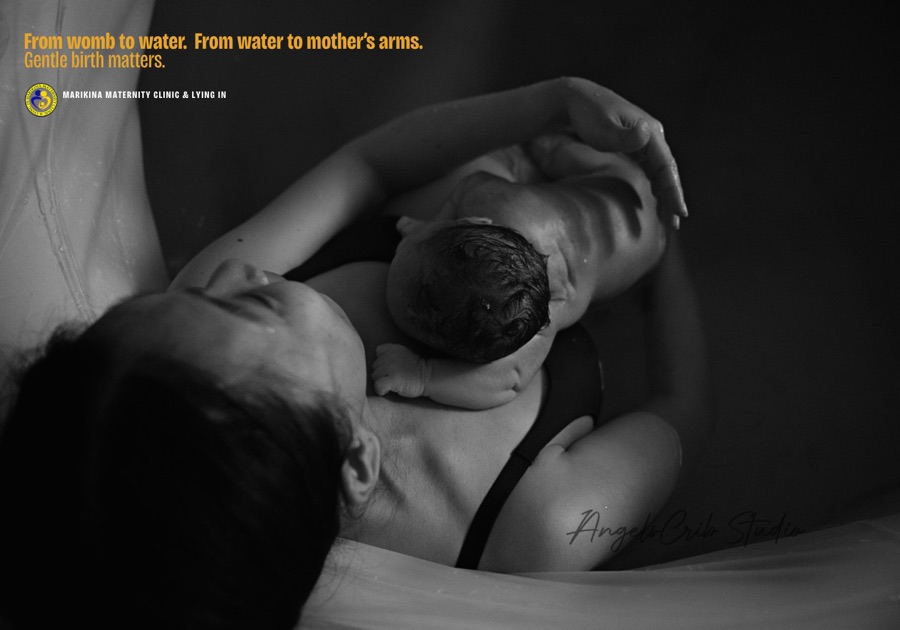 A mother holding her newborn in the birth pool