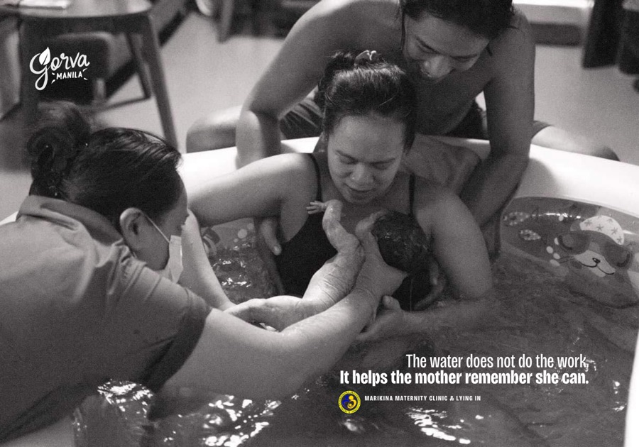 A mother supported by her partner and care team in water